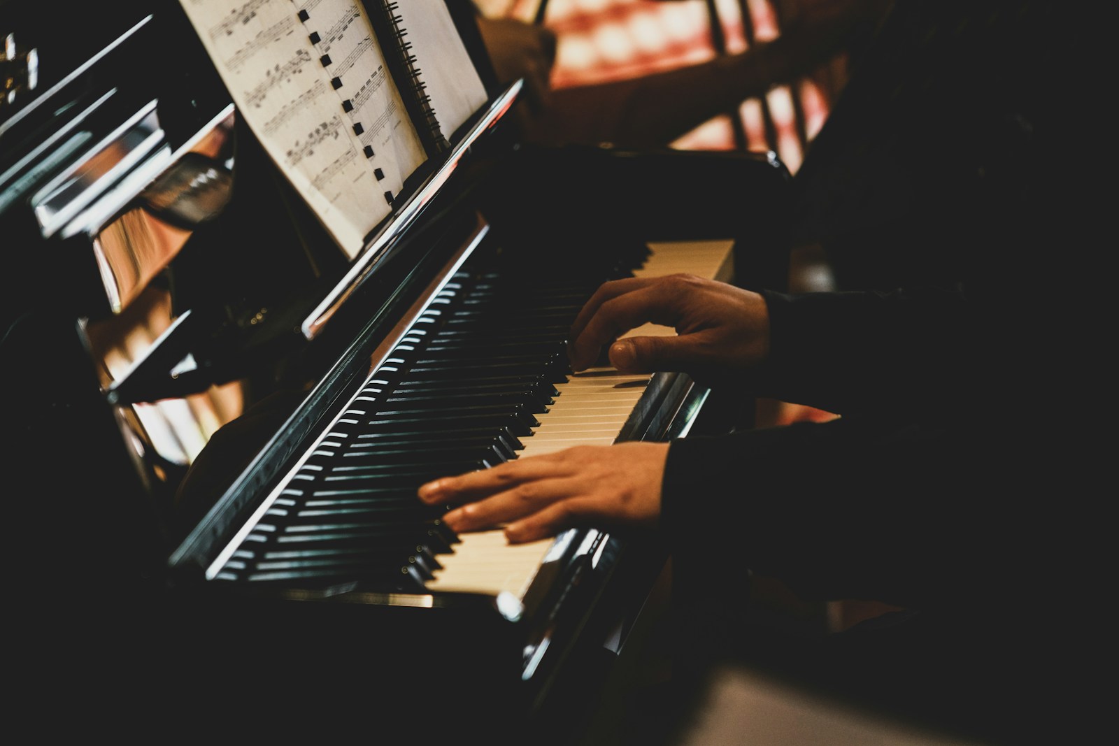 a person playing a piano in a dark room